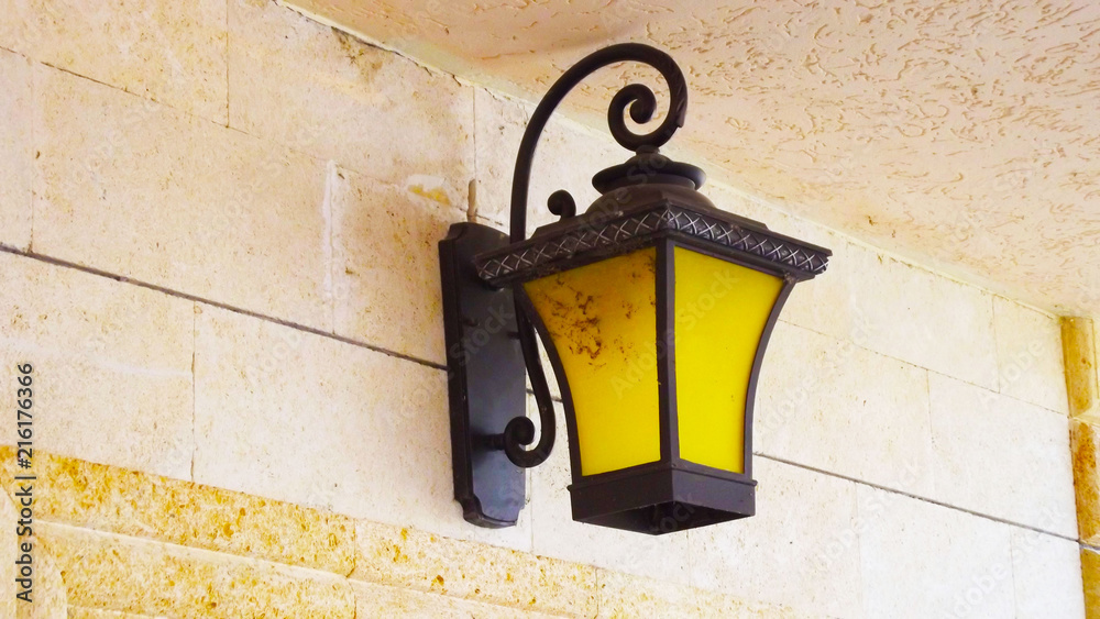 Beautiful yellow lantern on the wall outside. Beautiful yellow lantern on the wall outside.