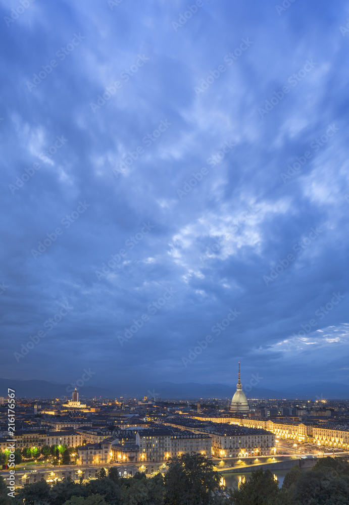 night sky with light clouds above night Turin in Italy