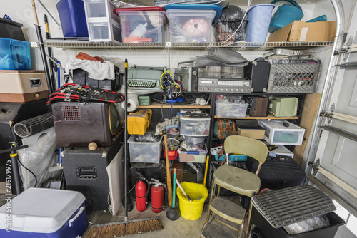 Messy cluttered junk filled suburban garage shelves with vintage electronics and sports equipment.  