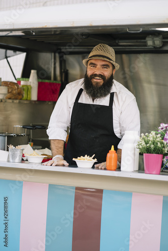 Smiling food vendor with beard in food truk