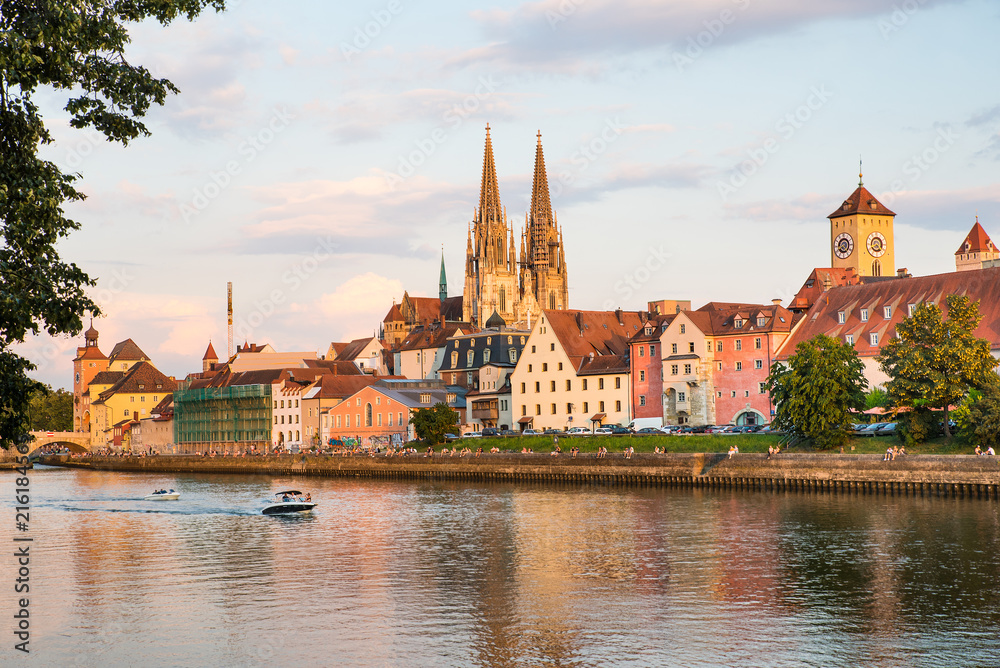 Regensburg city view, Germany. People enjoy beauty on Danube river shore, Regensburg Cathedral and architecture on background