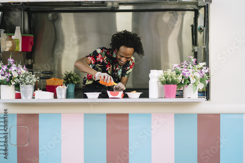 Smiling food vendor hands food to waiting customer photo