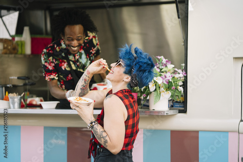 Smiling food vendor hands food to waiting customer photo