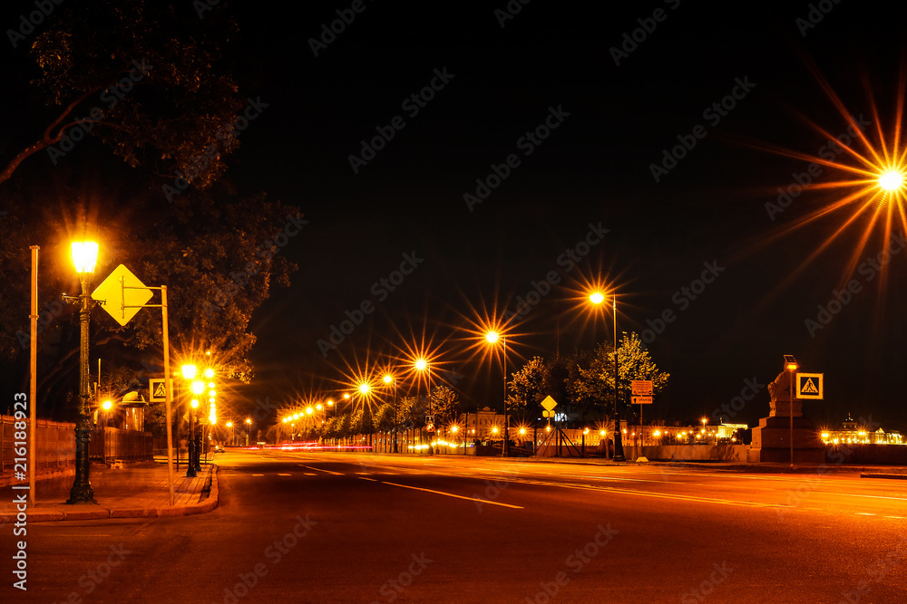 Night city street lights bokeh colorful background, the concept of darkness. The rays from the lights