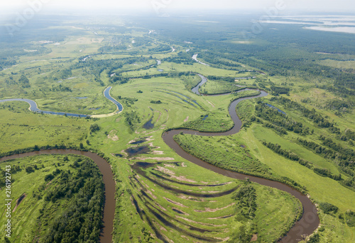Aerial landscape of winding river in green field. Aerial shoot of beautiful nature texture from drone