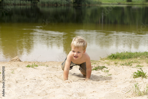 Little baby boy playing on beach. Summer water fun