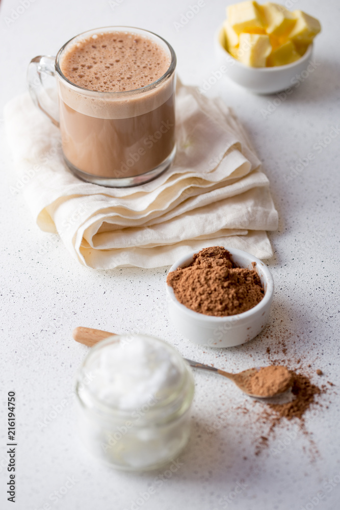 BULLETPROOF CACAO. Ketogenic keto diet hot drink. Cacao blended with coconut oil and butter. Cup of bulletproof cacao and ingredients on white background BULLETPROOF CACAO. Ketogenic keto diet hot drink. Cacao blended with coconut oil and butter. Cup of bulletproof cacao and ingredients on white background