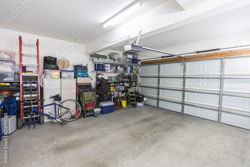 Organized suburban residential garage with shelves, file cabinets, tools and sports equipment.  