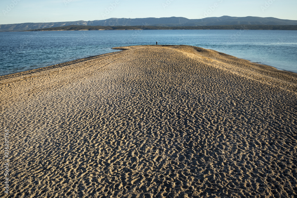 Sunset on pebble beach Golden cape (Zlatni rat) is one of most famous beach in Croatia, on south side of island Brac near town Bol Sunset on pebble beach Golden cape (Zlatni rat) is one of most famous beach in Croatia, on south side of island Brac near town Bol