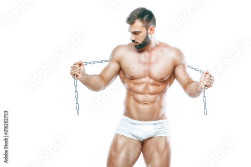 bodybuilder posing. Beautiful sporty guy male power. Fitness muscled manin white lingerie. on isolated white background. Posing with chain © satyrenko