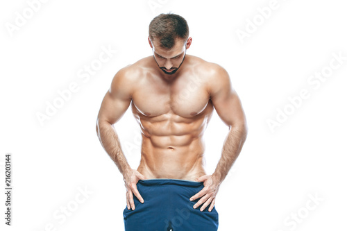 bodybuilder posing. Beautiful sporty guy male power. Fitness muscled in blue shorts. on isolated white background. Man with muscular torso. Strong Athletic Man Fitness Model Torso showing six pack abs