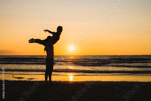 Silhouettes of two dancers doing acrobatics at sunset