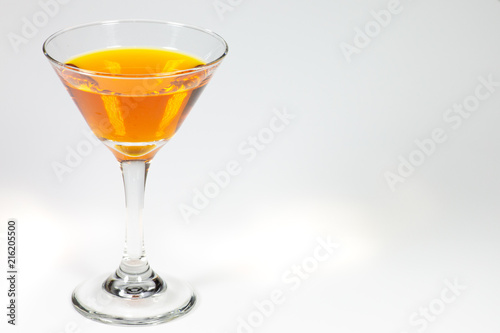 Wallpaper Mural Halloween inspired orange color cocktail in a clear glass sitting on a white table waiting to be enjoyed. Torontodigital.ca