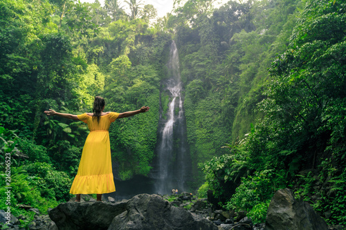 Φωτογραφία Woman in yellow dress at the Sekumpul waterfalls in jungles on Bali island, Indo