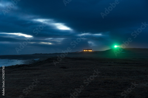 lighthouse by the icelandic ocean shore