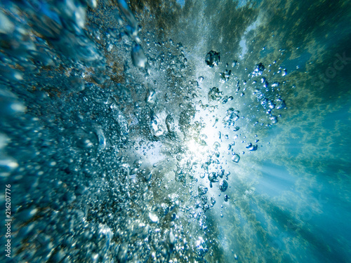 Scuba bubbles rising through rays of sunlight from the surface