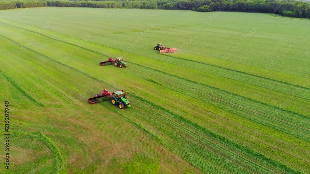 Tractors harvesting crop at dusk, teamwork in agriculture, aerial view.
Tractors harvesting crop at dusk, teamwork in agriculture, aerial view.