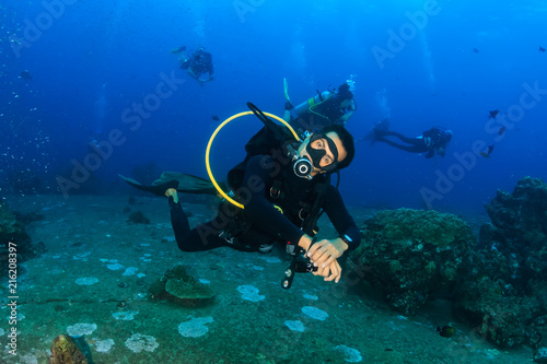SCUBA diver swimming along a tropical coral reef