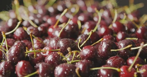Close-up of a red ripe cherries with drops of water fall on berries. Cherries falls on berries background. Dolly-in slow motion with changing focus. Soft focus. Full HD video, 240fps,1080p