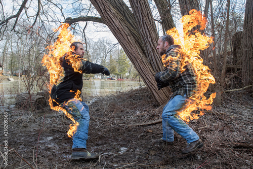 Obraz na płótnie Stunt Men light themselves on fire and fight in their backyard w salonie