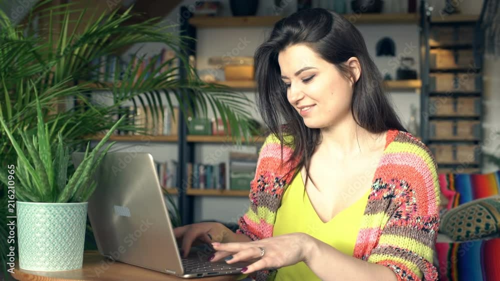 Beautiful woman smiling to the camera while using modern notebook
Beautiful woman smiling to the camera while using modern notebook