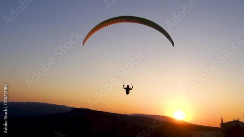 Close-up: paraglider is flying in the direction of the Sun photo