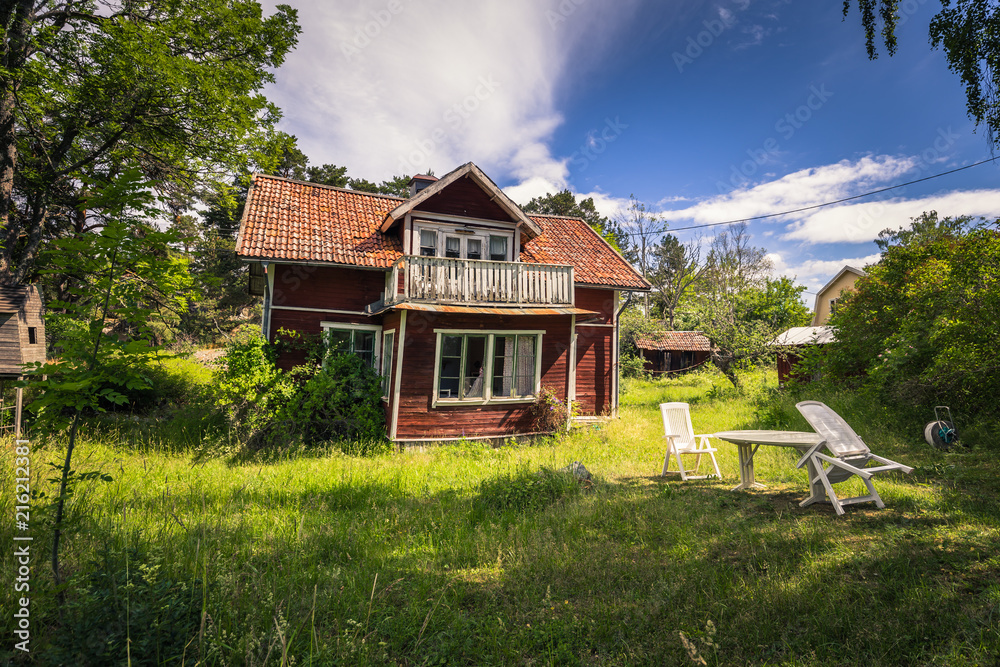 Small red house in a small island during Midsummer in the Swedish Archipelago, Sweden