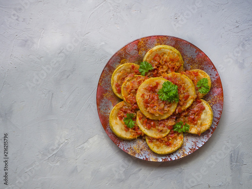 Zucchini fried with slices of vegetable sauce on a plate. Cold snack.