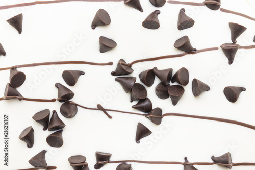 close up of chocolate chips topped white chocolate background