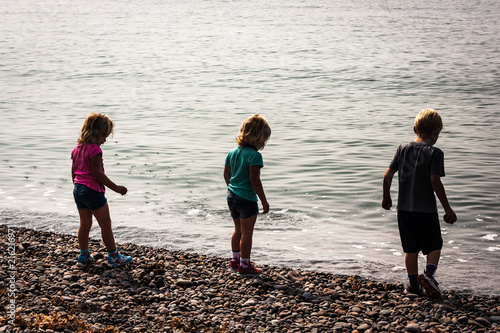 Children playing with stones on a beach