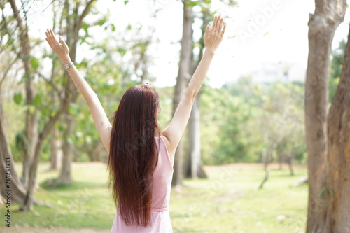 Young woman with long brown hair. Relaxing with deep clear air and blur background natural and tree.