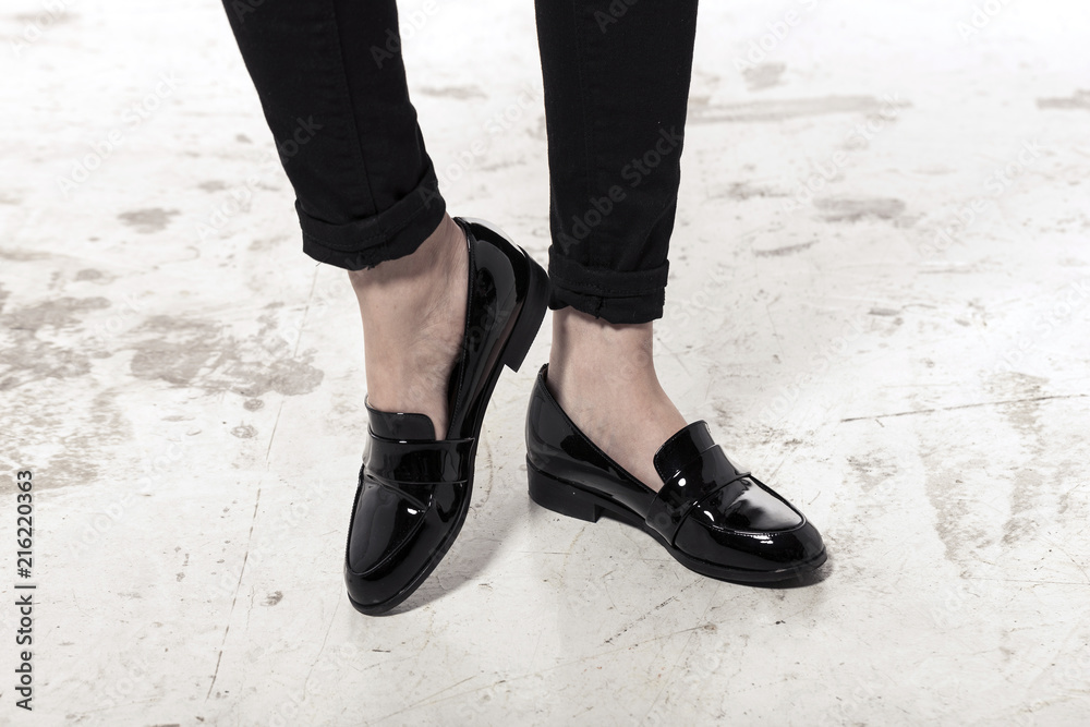 woman wearing black enamel shoes isolated white.