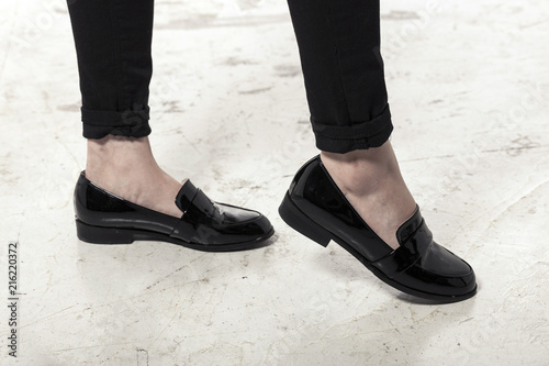 woman wearing black enamel shoes isolated white.