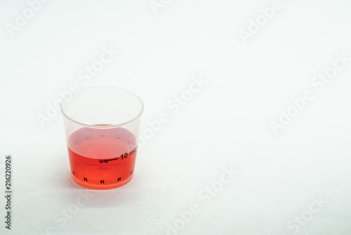 Isolated measurement cup with cold medication in it