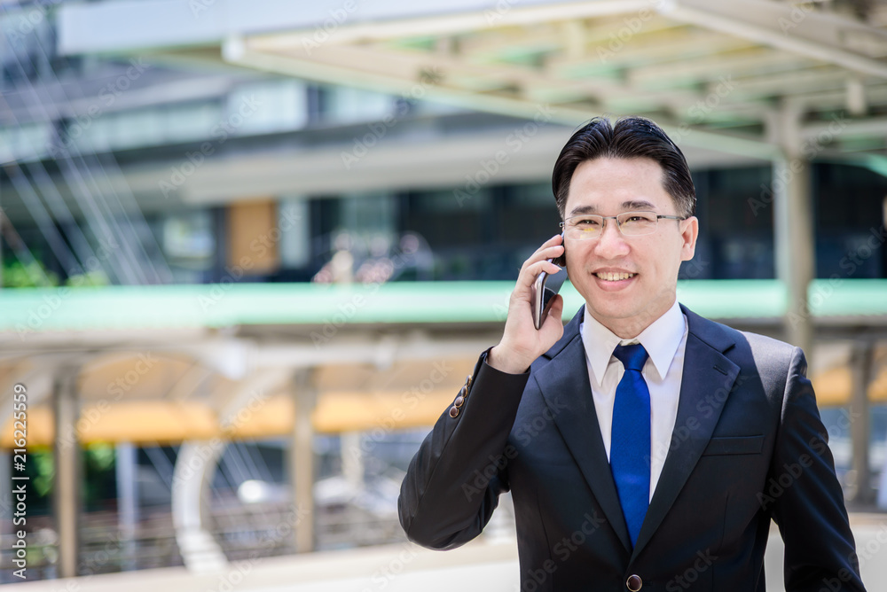 The asian businessman has working on mobile with happy. The asian businessman has working on mobile with happy.