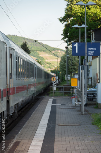 White train passing through station with focus on platform number