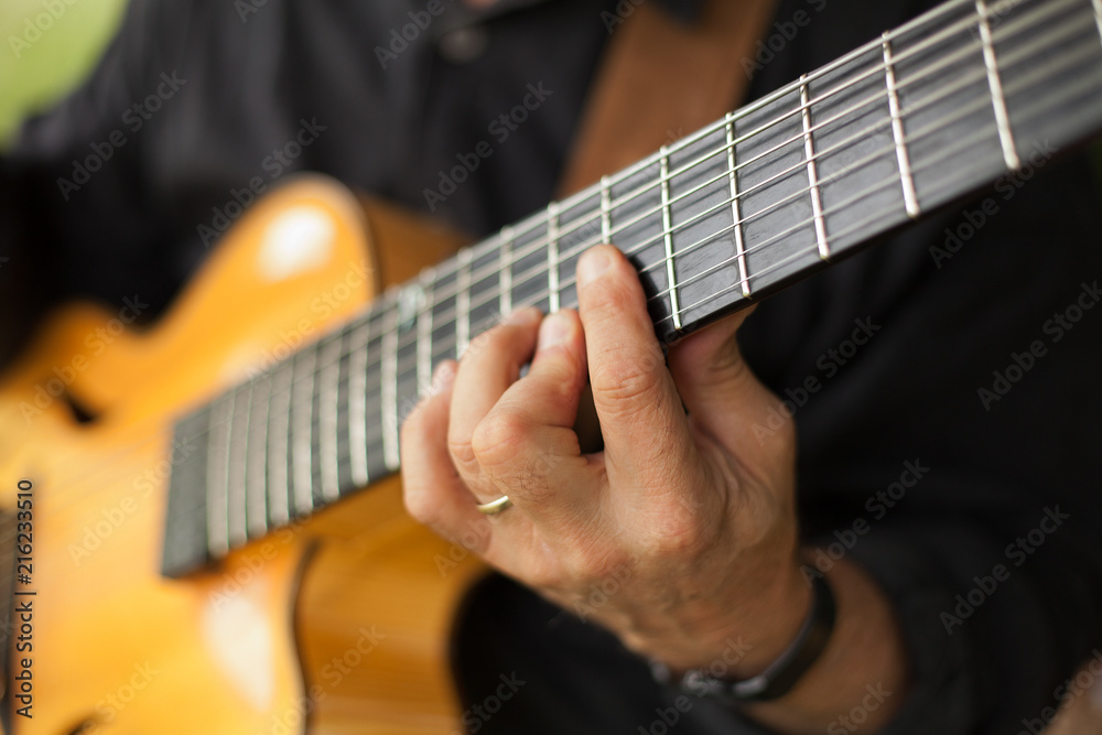 Detail of guitarist playing seven string guitar
