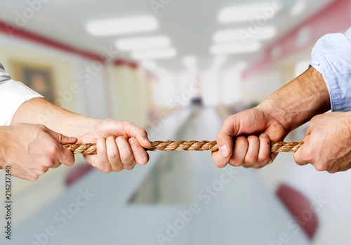 Business people pulling rope in opposite directions