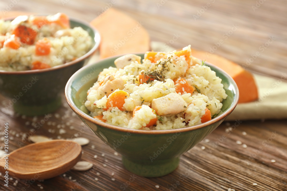 Bowl with delicious pumpkin risotto on wooden table