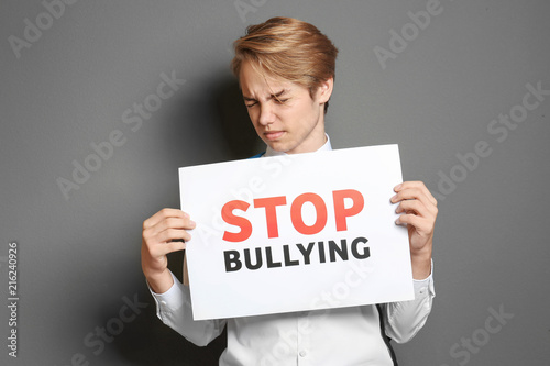 Teenage boy holding sign wi...