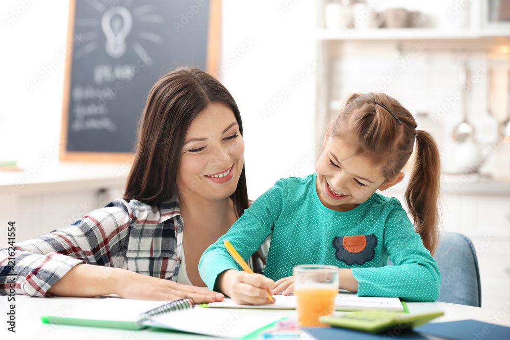 Cute little girl doing homework with mother Cute little girl doing homework with mother