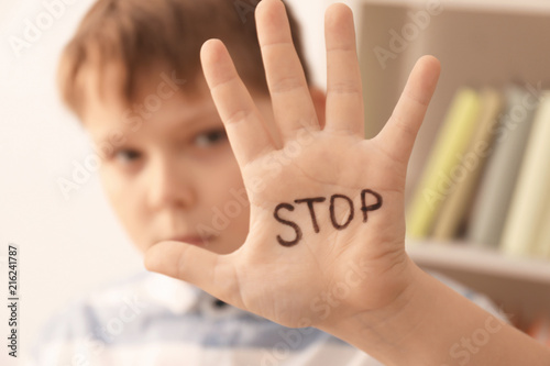 Little boy with word "Stop" indoors