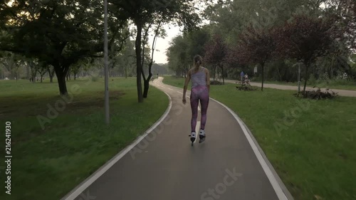 Wallpaper Mural White hansom brown hair girl in tight pants woman riding rollers skates on bike road in parky, summer golden hour Torontodigital.ca