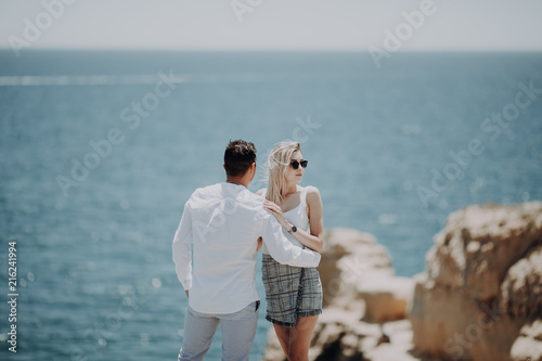 Couple staying on the cliff with beautiful ocean view. photo