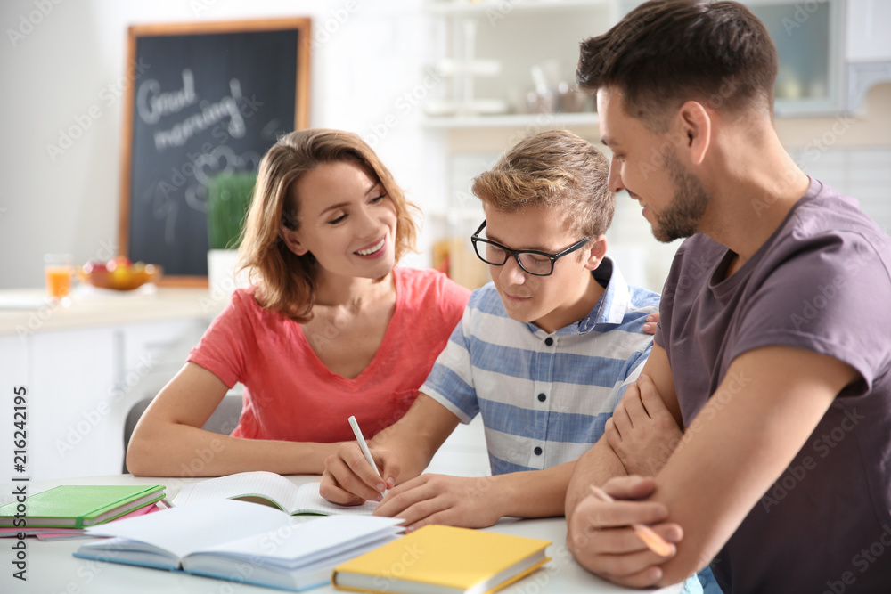 Teenager with parents doing homework at home Teenager with parents doing homework at home