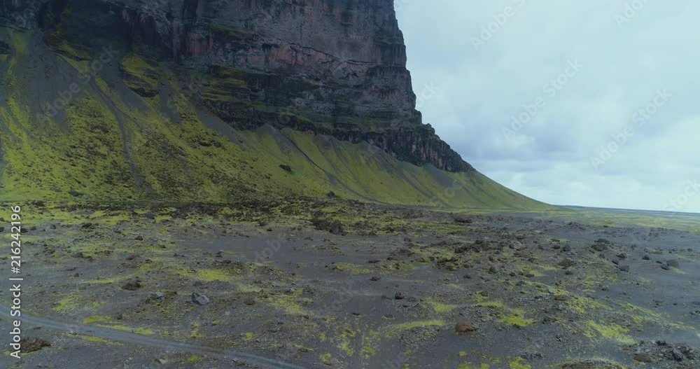 Aerial view of lava field with cliffs in the distance