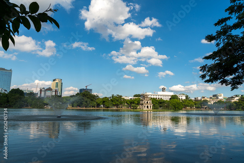 Hoan Kiem lake or Sword lake, Ho Guom in Hanoi, Vietnam with Turtle Tower, on clear day with blue sky and white clouds photo