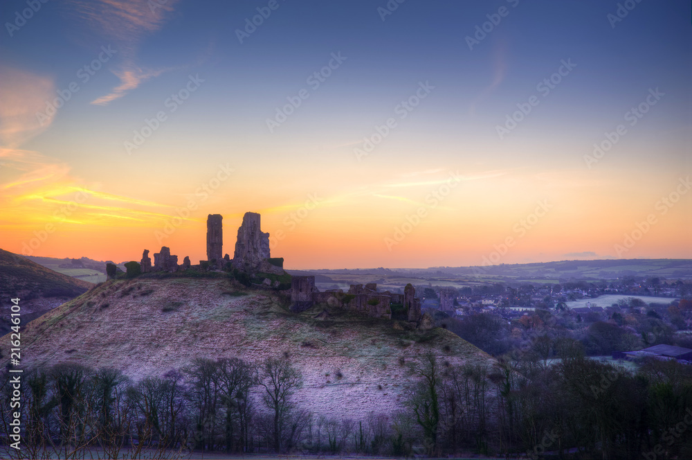 Beautiful Medieval castle ruin in countryside landscape during Winter sunrise