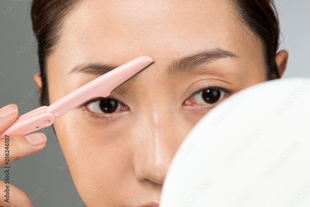 Obraz premium 眉の間を剃る女性