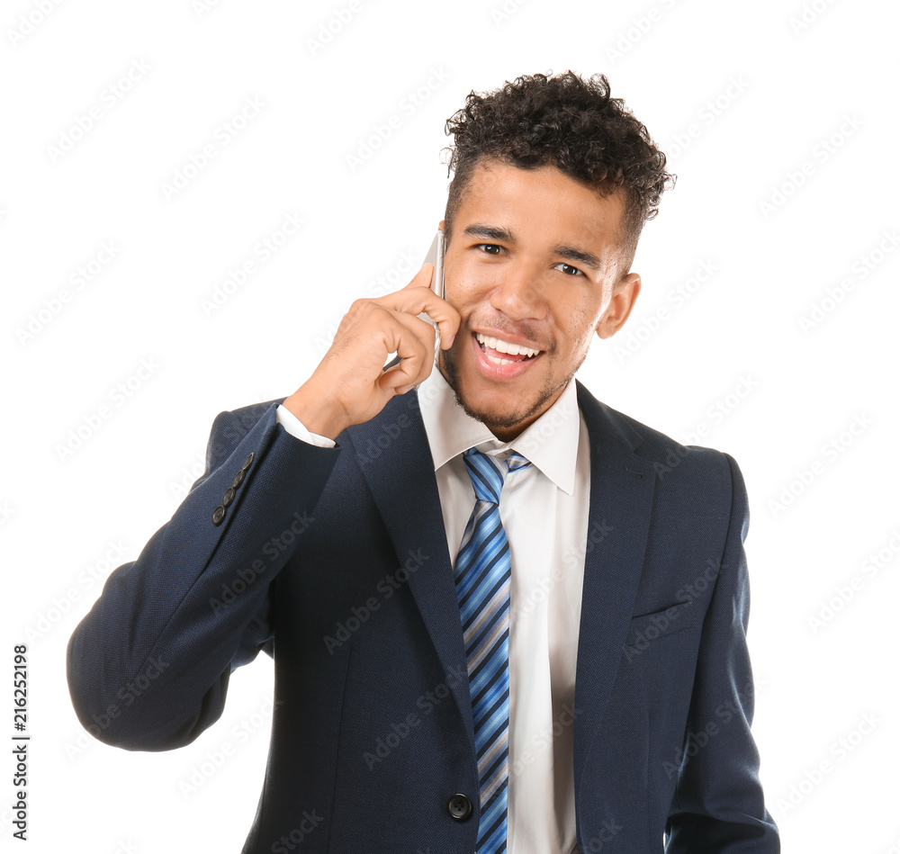 Handsome African-American businessman talking by mobile phone on white background